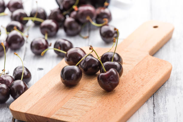 istock Cherries on wooden table with water drops background 909617178
