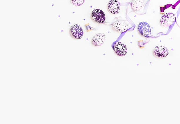 Stylish frame background with easter eggs and silk ribbons. Purple, lilac and white easter eggs with copy space for text. Isolated on white background. Flat lay, top view. Easter concept
