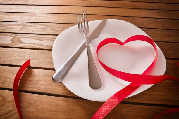 istock Table decorated with ribbon forming a heart elevated view 909640092