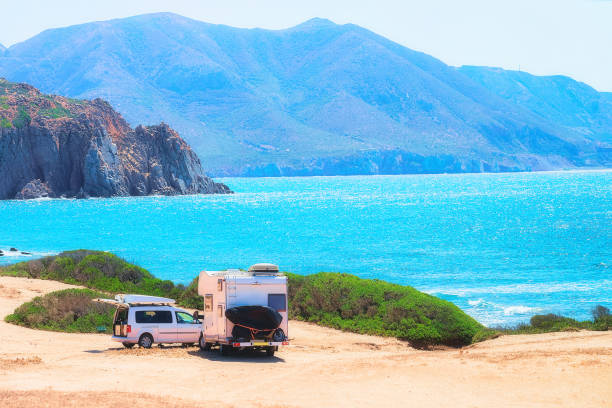 istock Car and Camper at Capo Pecora Mediterranean sea Sardinia 909644968