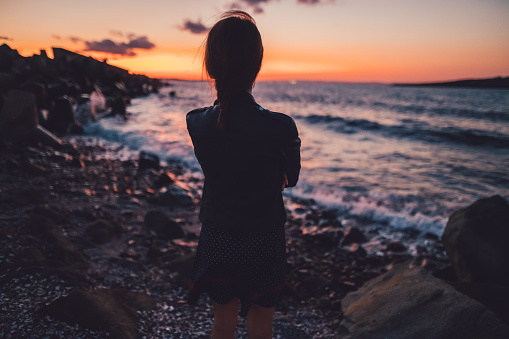 Young woman at the seashore during sunset