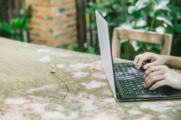 istock closeup hand working with laptop computer in green space cafe on wood table 909646212