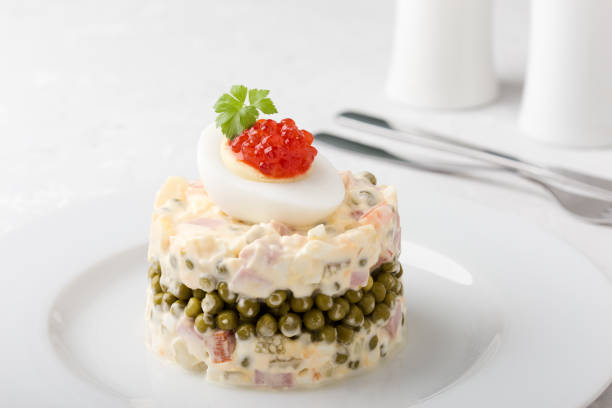 Traditional russian dish Olivier salad served with red caviar on top