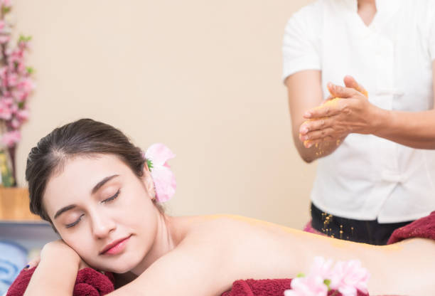 istock Spa therapist is dropping salt scrub on to a woman back 909651526