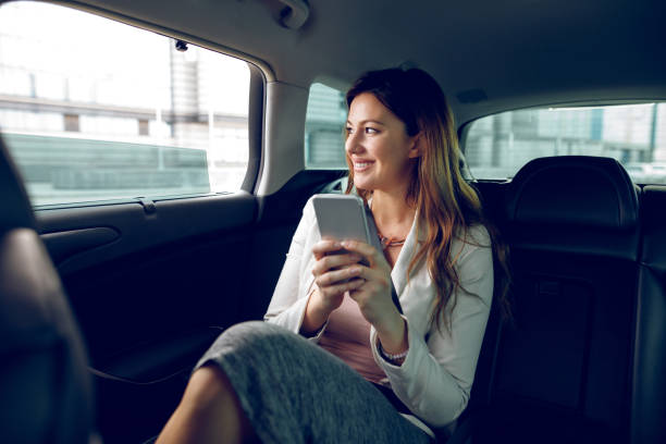 istock Successful businesswoman in a car using mobile phone 909660622