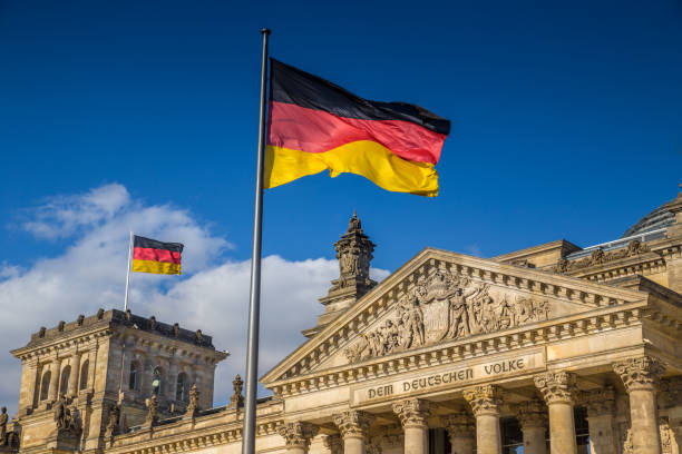 German flags at Reichstag, Berlin, Germany German flags waving in the wind at famous Reichstag building, seat of the German Parliament (Deutscher Bundestag), on a sunny day with blue sky and clouds, central Berlin Mitte district, Germany chancellor photos stock pictures, royalty-free photos & images