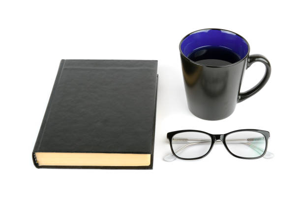 istock Book, cup with tea and glasses isolated on white background. All objects are black. 909665196