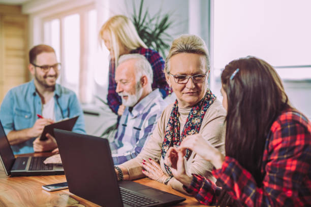 istock Young volunteers help senior people on the computer 909665666