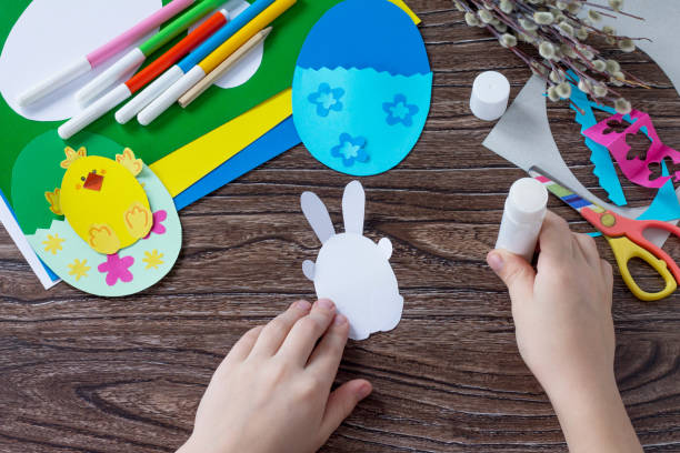 istock A child draws details of an easter egg gift with a chicken and Easter bunny toy. Handmade. Project of children's creativity, handicrafts, crafts for kids. 909675174
