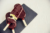 popsicle with grated chocolate on a wooden background