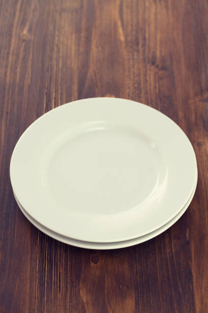 istock white plates on brown wooden background 909681140
