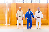 Three Senior Adults in Judo Uniforms in the Gym
