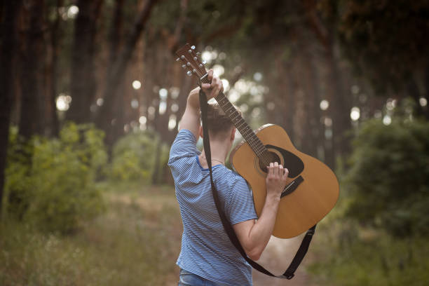 istock Talented guitarist playing forest hiking concept. 909682420