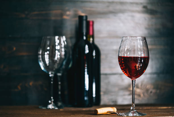 istock bottles with red wine and wine glasses on a wooden surface 909683128