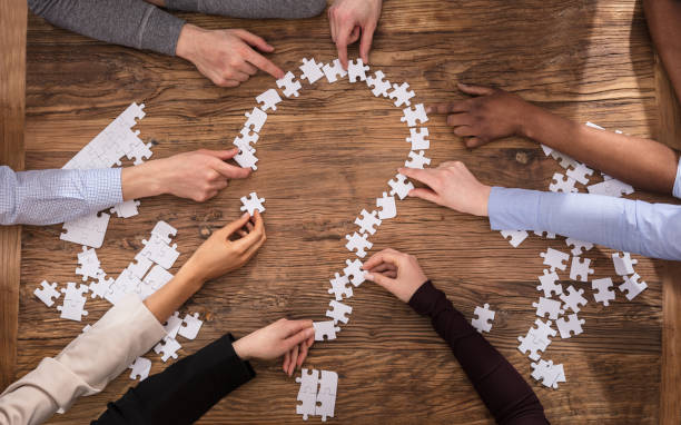 istock Businesspeople Making Question Mark Sign With Jigsaw Puzzle 909688948