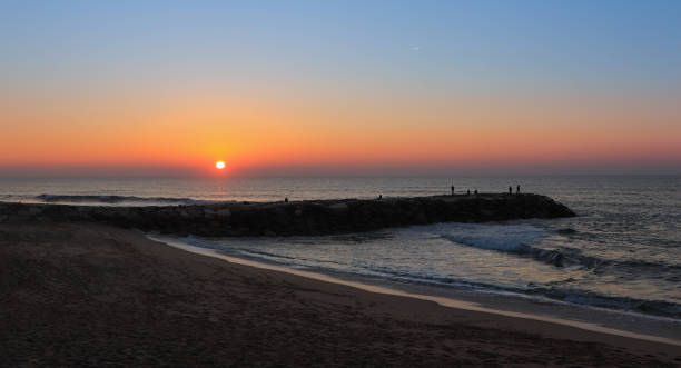 istock Amazing sunset over a beach with a jetty 909699982