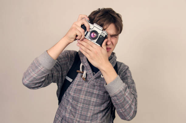 istock Teenager holding analog camera and taking picture 909700672