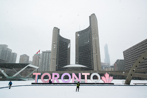 Toronto, Canada, circa february 2017: Nathan Phillips square in snowy winter and Toronto sign.