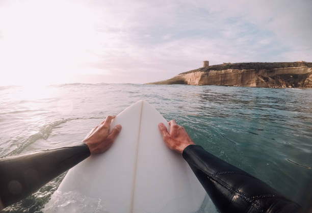 istock Surfer holding a surfboard in the water (point of view) 909701146