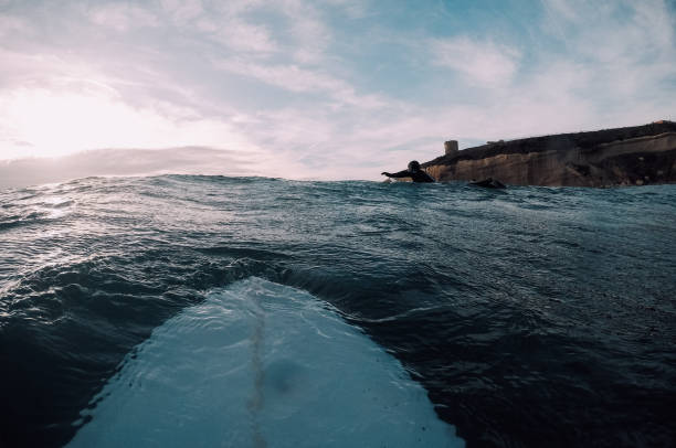 istock Surfboard and surfer in the sea 909701300
