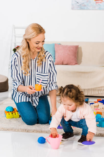 istock happy mother and daughter playing with plastic cups 909708452
