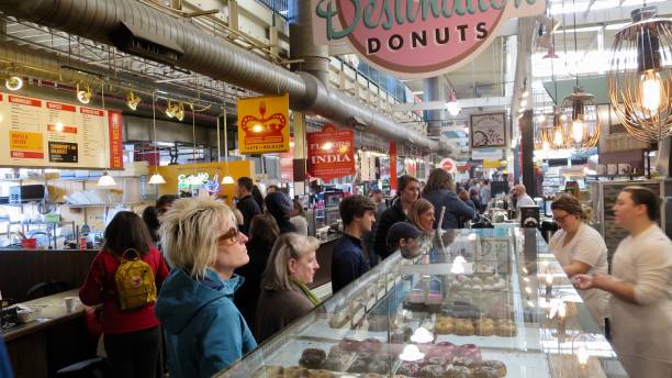 Shoppers at North Market in Downtown Columbus Ohio View of shoppers in Downtown Columbus Ohio's North Market near the Destination Donuts stand columbus stock pictures, royalty-free photos & images