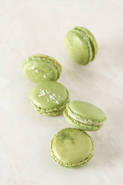 istock French dessert macaroons with pistachios and strawberries. White background 909713788