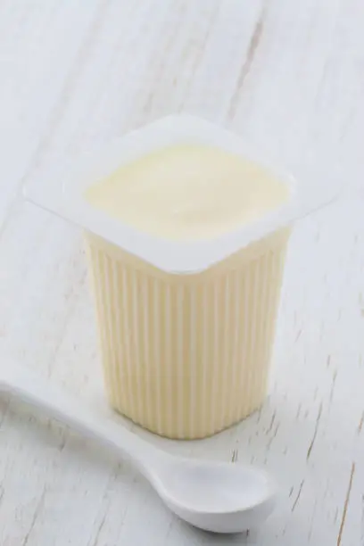Delicious nutritious and healthy fresh plain yogurt cup. On vintage retro styling.