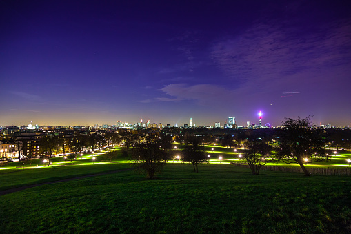 Image taken from Primrose Hill in Regent's Park, looking across a green lawn towards the  City of London in the distance. Part of a series.
