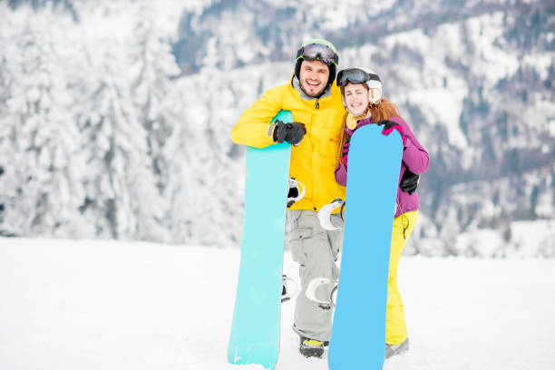 istock Couple with snowboards on the snowy mountains 909722648