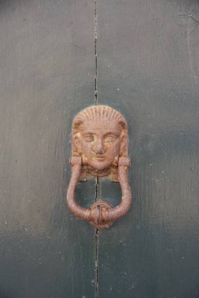 istock Sphinx doorknob on a green door 909722840