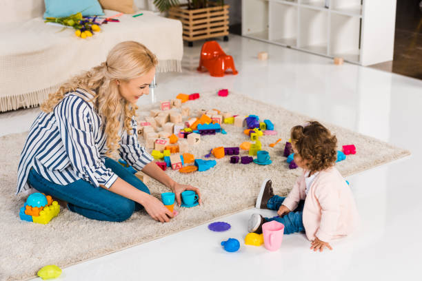 istock smiling mother and daughter playing with plastic cups 909728840