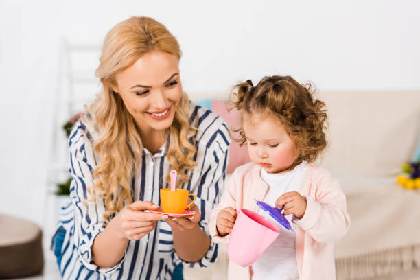 istock smiling mother and daughter playing with plastic cups 909729018