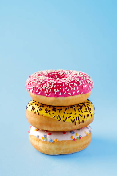 istock Donuts selection on blue background. Various doughnuts isolated on colorful background 909729510