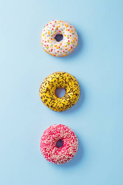 istock Donuts selection on blue background. Various doughnuts isolated on colorful background 909729512