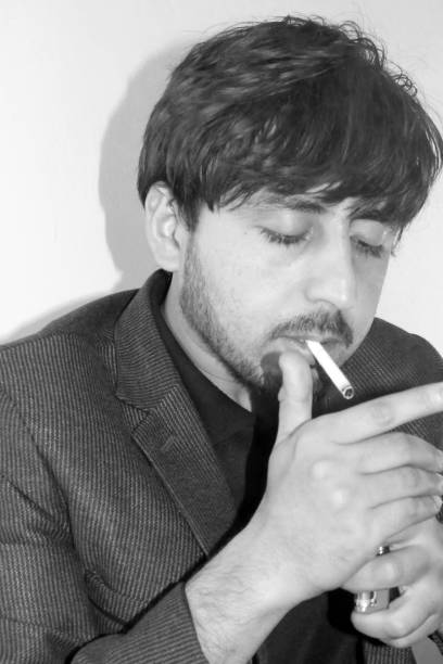 istock Closeup Handsome Young Man Smoking Cigarette 909729930