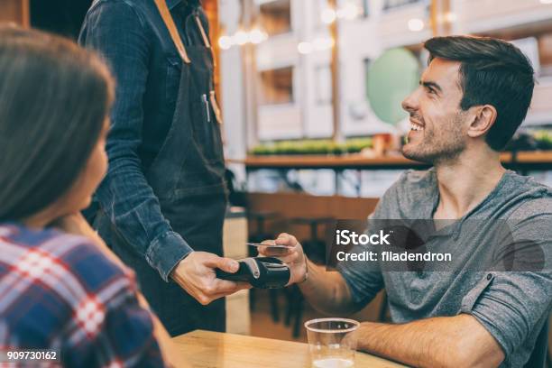 Boyfriend Pays The Bill Via Credit Card Stock Photo - Download Image Now - Credit Card, Restaurant, Financial Bill