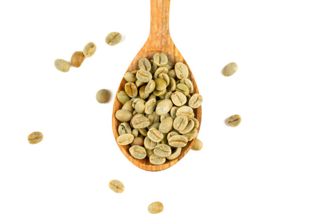 chicchi di caffè verde in un cucchiaio di legno - coffee crop bean seed directly above foto e immagini stock