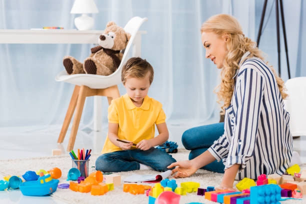 istock young mother helping son while drawing picture together at home 909739402