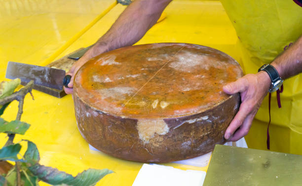 istock Cutting hard cheese in grocery shop 909741920