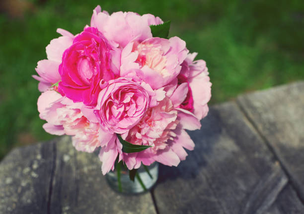 istock peony and rose bouquet on wooden surface 909741956