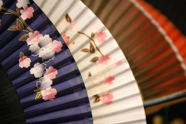 Hand holding chinese fan on a white background