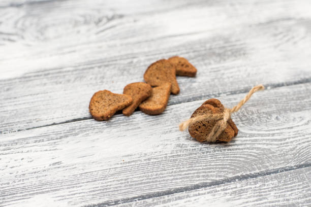 istock Pieces of black crackers on a light wooden background 909743600