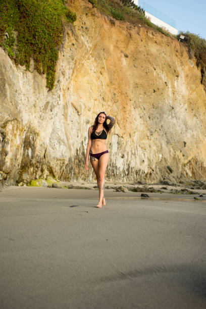 Young attractive woman strolling on a Southern California beach stock photo