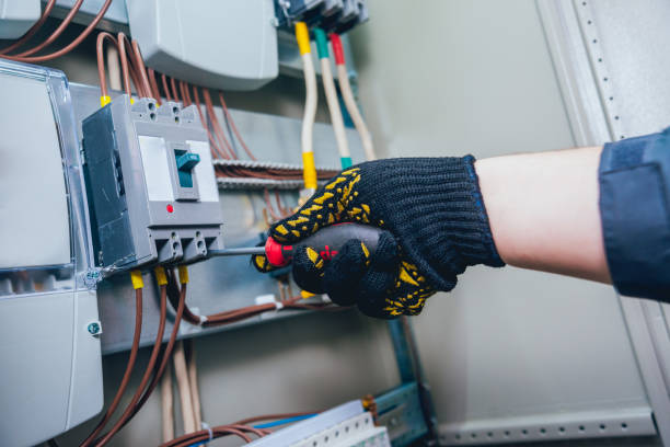 istock Electricians hands testing switches in electric box. Electrical panel with fuses and contactors 909755414