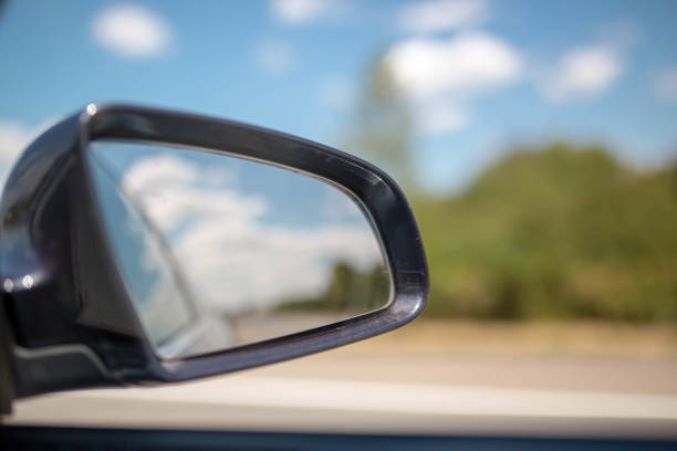istock Traveling, rear view mirror road view and clouds 909755836