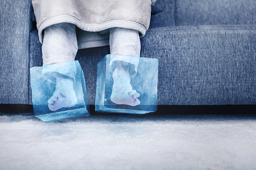 Person sitting on the sofa with feet that turned into ice cubes.