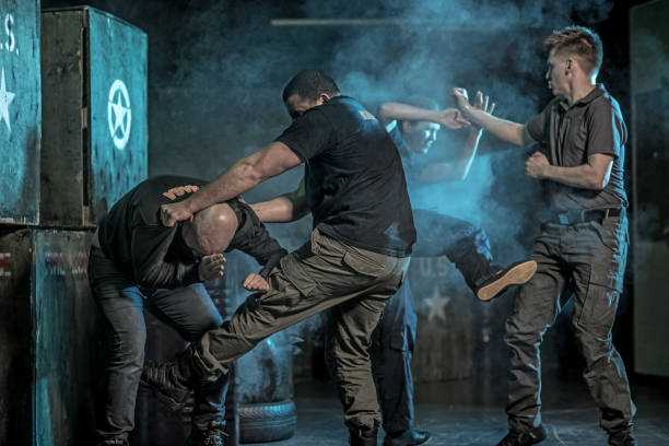 istock Krav Maga fighting group training in dark indoor urban setting 909762000