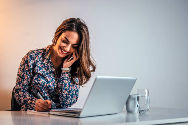 istock Young businesswoman talking on the phone in office and taking notes. 909762298