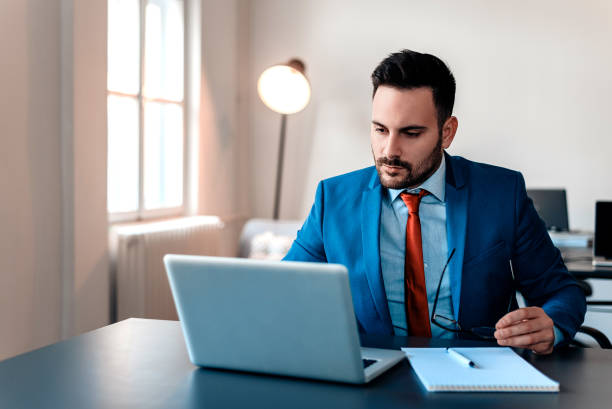 istock Busy businessman in office working on laptop. 909762406